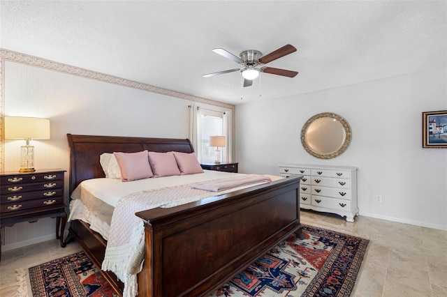 bedroom with ceiling fan and a textured ceiling