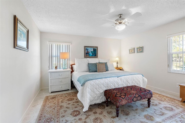 bedroom with ceiling fan and a textured ceiling