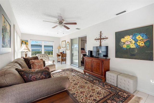 tiled living room featuring ceiling fan and a textured ceiling