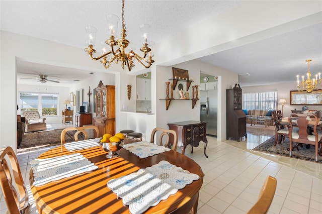 dining space with ceiling fan with notable chandelier, plenty of natural light, a textured ceiling, and light tile patterned flooring