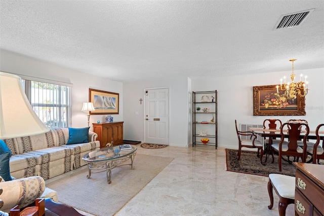 living room with a chandelier and a textured ceiling