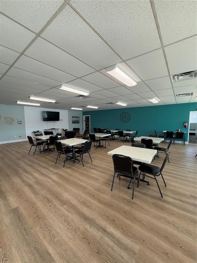 dining area featuring hardwood / wood-style floors and a paneled ceiling