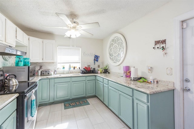 kitchen with tasteful backsplash, ceiling fan, stainless steel electric stove, white cabinetry, and a sink