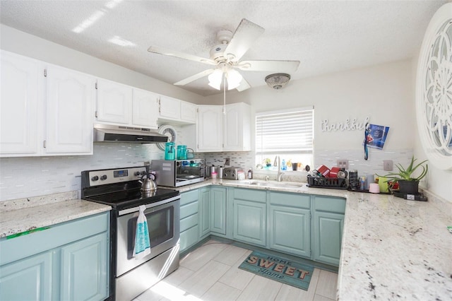 kitchen featuring under cabinet range hood, stainless steel appliances, a sink, white cabinetry, and decorative backsplash