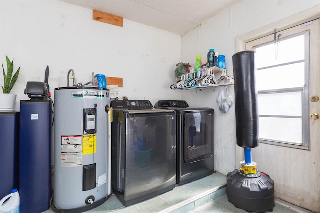 clothes washing area with laundry area, washing machine and dryer, and water heater