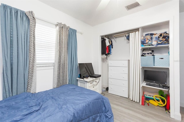 bedroom featuring a ceiling fan, a closet, visible vents, and light wood-style flooring