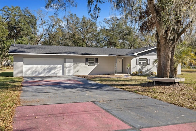 ranch-style home with a garage and a front lawn