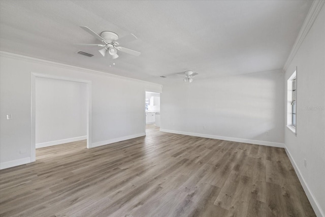 empty room featuring crown molding, ceiling fan, and wood-type flooring