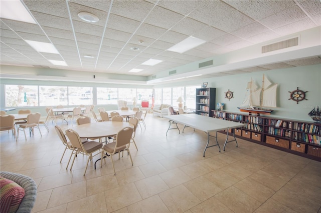 dining space with a wealth of natural light and a paneled ceiling