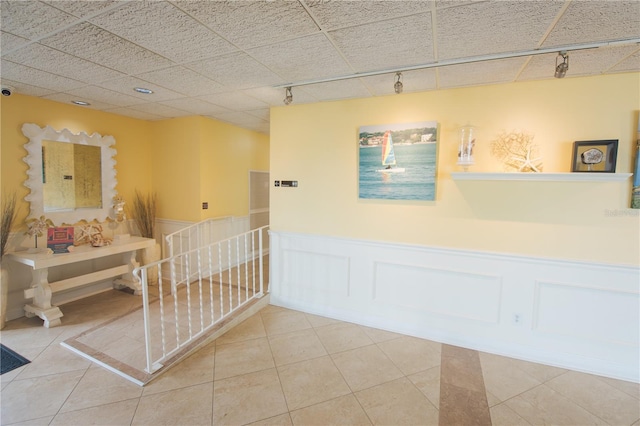 hallway featuring track lighting and tile patterned flooring