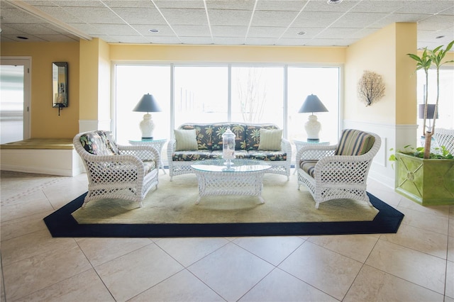 interior space with a drop ceiling and light tile patterned floors