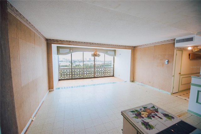 unfurnished room featuring wooden walls and a textured ceiling