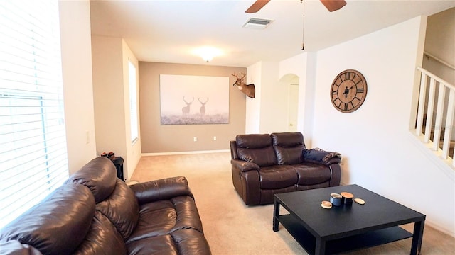 living room featuring a healthy amount of sunlight, light colored carpet, and ceiling fan