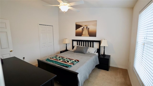 bedroom with light carpet, lofted ceiling, a closet, and ceiling fan