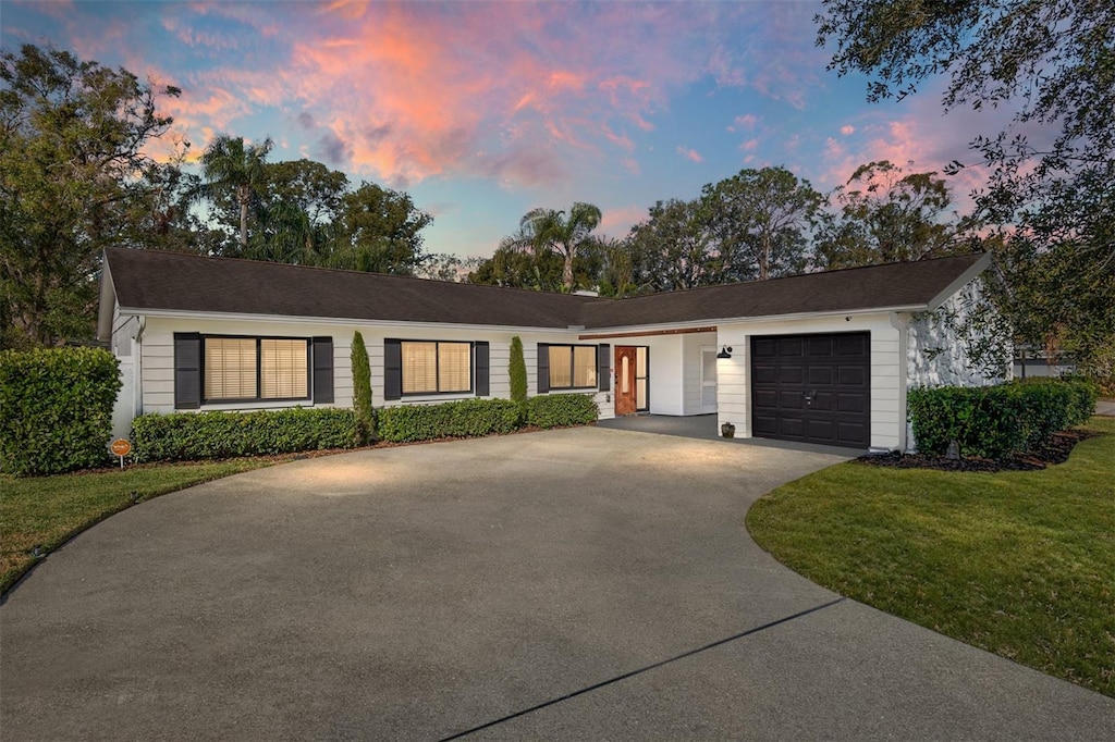 ranch-style house with a yard and a garage