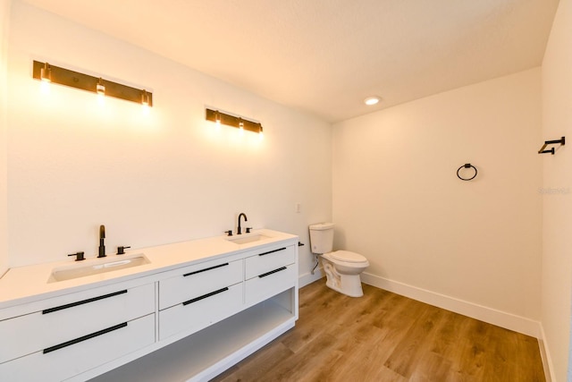 bathroom featuring vanity, wood-type flooring, and toilet