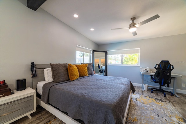 bedroom with lofted ceiling, dark hardwood / wood-style floors, and multiple windows