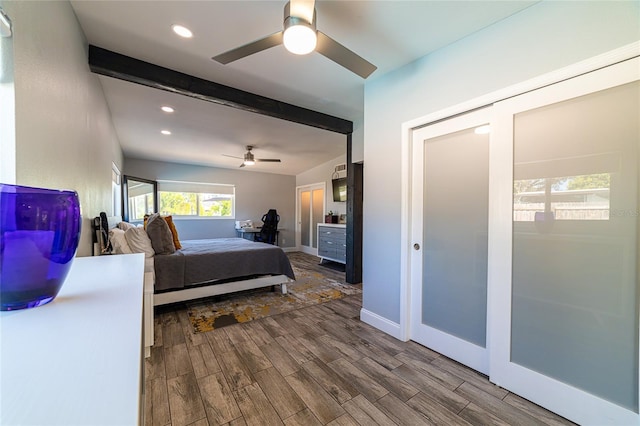 bedroom featuring beam ceiling, hardwood / wood-style floors, and ceiling fan