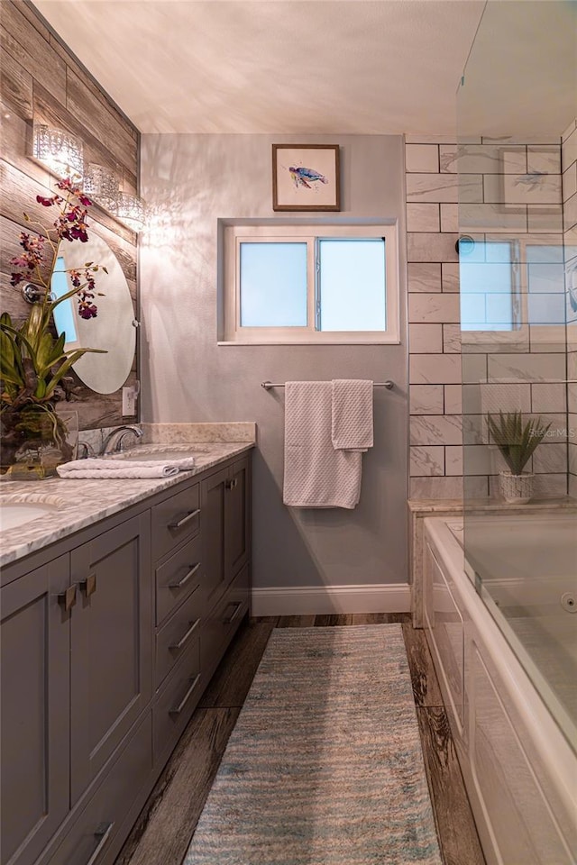 bathroom featuring hardwood / wood-style flooring, vanity, and a washtub