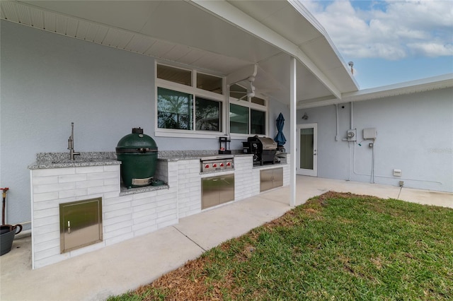 view of patio with area for grilling and ceiling fan