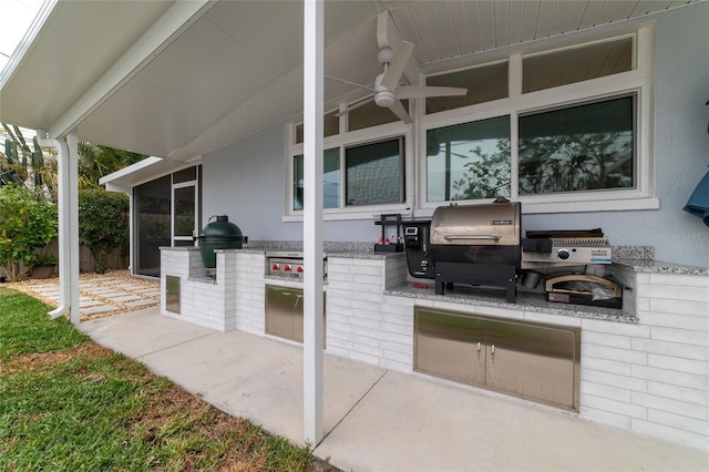 view of patio featuring grilling area, ceiling fan, and exterior kitchen