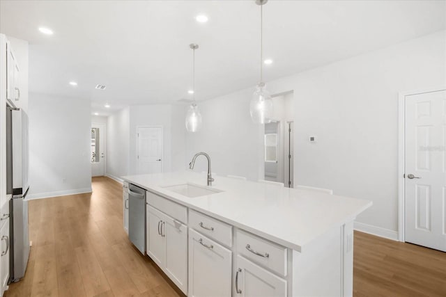 kitchen featuring white cabinetry, sink, an island with sink, and appliances with stainless steel finishes