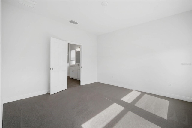 unfurnished room with dark carpet