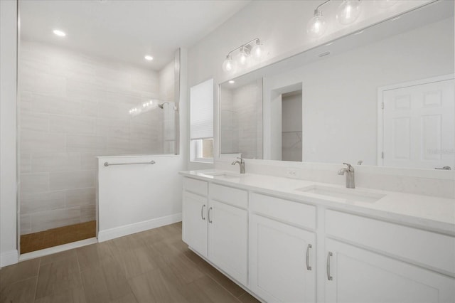 bathroom with vanity and a tile shower