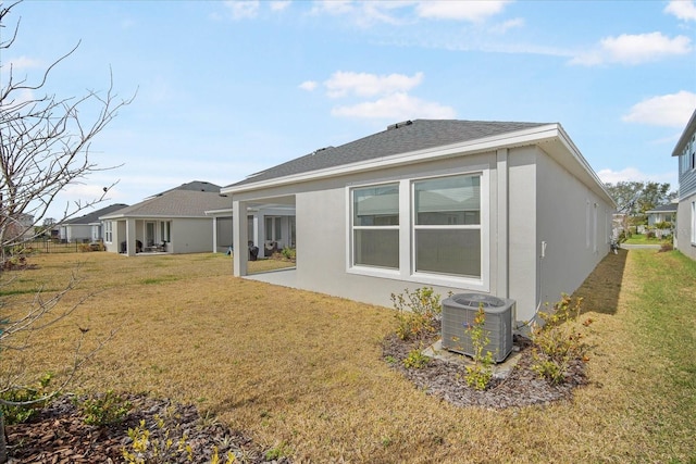 rear view of property featuring cooling unit, a patio, and a lawn