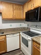 kitchen with white appliances, dark wood-type flooring, and light stone countertops