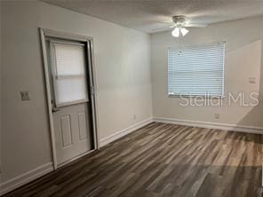 unfurnished room featuring dark hardwood / wood-style flooring and ceiling fan