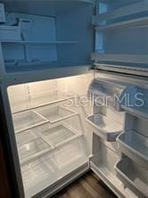 interior details with fridge and dark hardwood / wood-style flooring