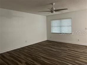 spare room with ceiling fan and dark hardwood / wood-style flooring