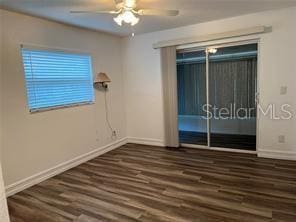 empty room with dark wood-type flooring and ceiling fan