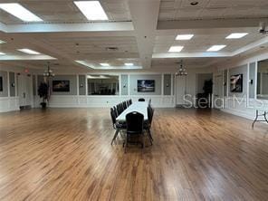 unfurnished dining area with hardwood / wood-style flooring, coffered ceiling, and a skylight