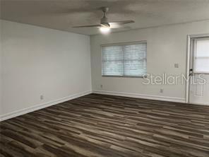 401 Dorchester Pl Unit 62, Sun City Center, FL 33573 - empty room featuring ceiling fan, wood finished floors, and baseboards