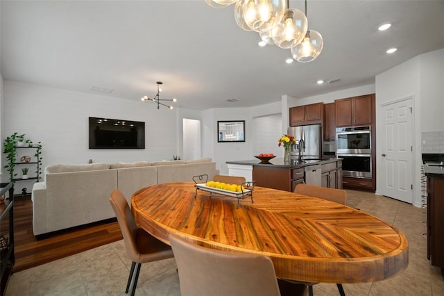 tiled dining room featuring an inviting chandelier