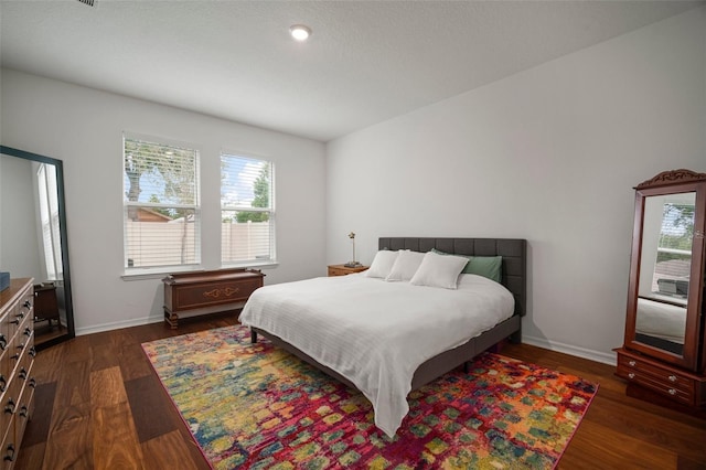 bedroom with dark hardwood / wood-style floors