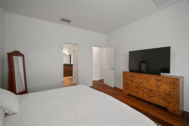 bedroom featuring wood-type flooring and connected bathroom