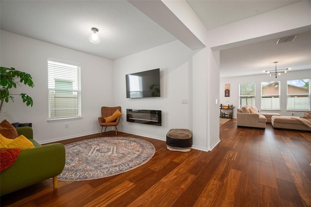 living area featuring dark hardwood / wood-style flooring and a chandelier