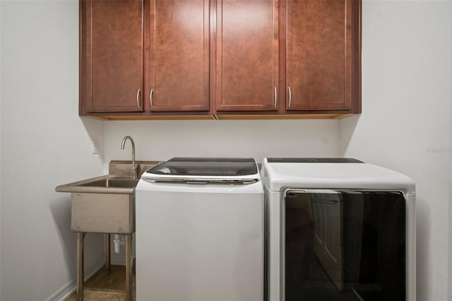 clothes washing area with cabinets and washer and dryer