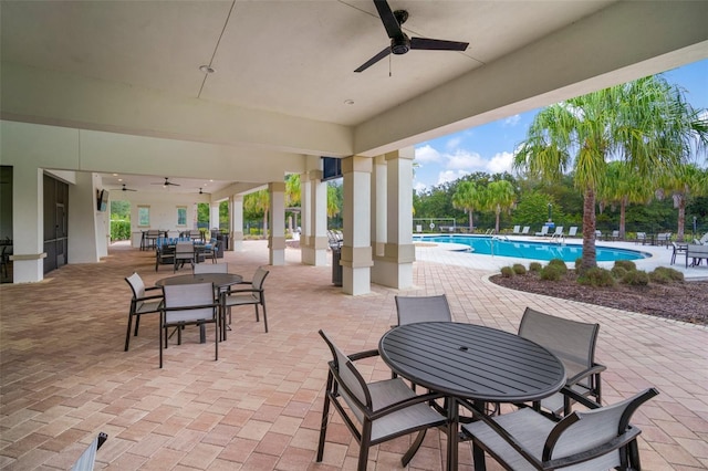 view of patio with a community pool and ceiling fan