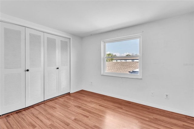 unfurnished bedroom featuring a closet and light wood-type flooring