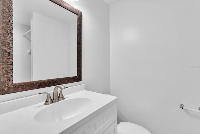 bathroom with vanity, a shower, and toilet