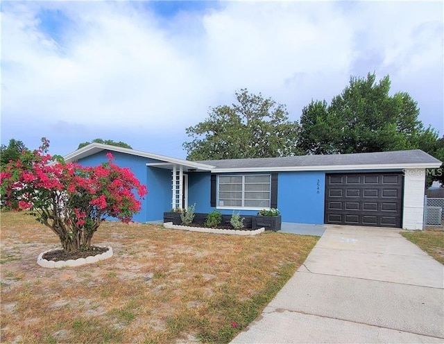 single story home featuring a garage and a front yard