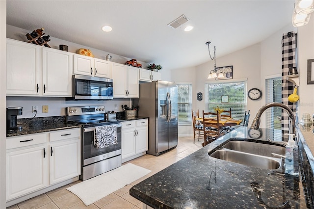 kitchen with sink, white cabinets, hanging light fixtures, light tile patterned floors, and stainless steel appliances