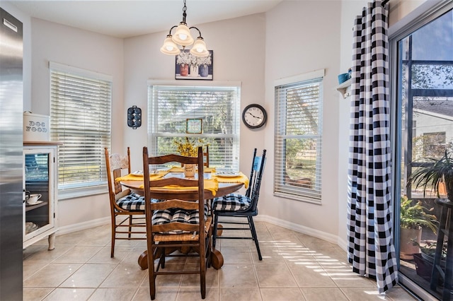 tiled dining room featuring vaulted ceiling and a healthy amount of sunlight