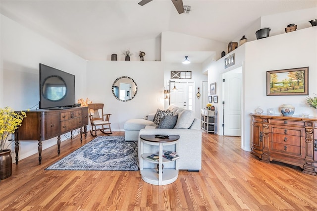 living room with vaulted ceiling, ceiling fan, and light wood-type flooring