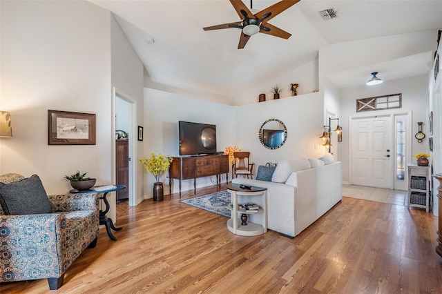 living room featuring ceiling fan, high vaulted ceiling, and light wood-type flooring