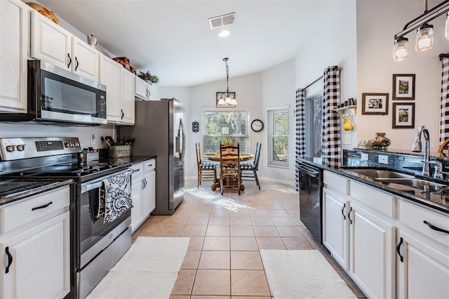 kitchen featuring light tile patterned flooring, sink, appliances with stainless steel finishes, pendant lighting, and white cabinets